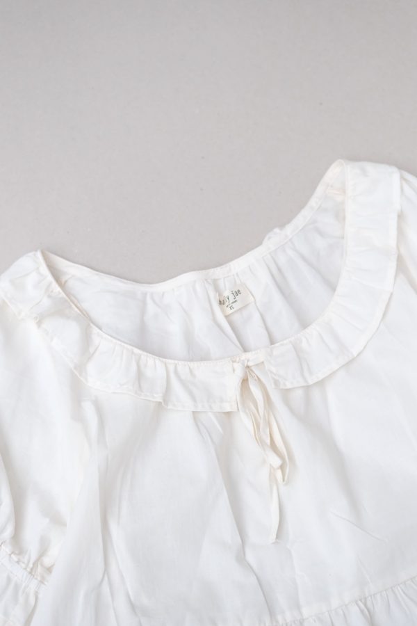 flatlay of the organic cotton Doll Blouse in Whipped Butter by the brand Harly Jae