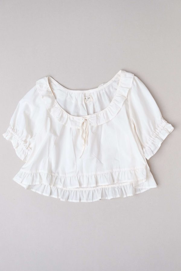 flatlay of the organic cotton Doll Blouse in Whipped Butter by the brand Harly Jae