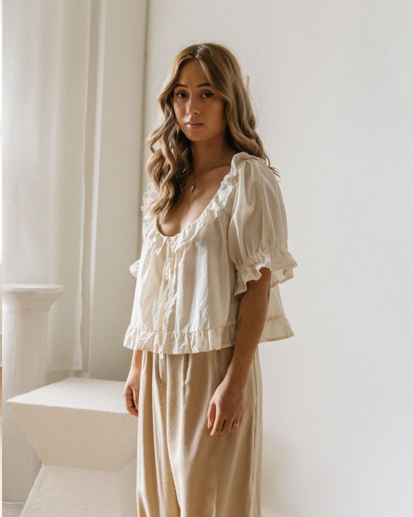 woman wearing the organic cotton Doll Blouse in Whipped Butter by the brand Harly Jae