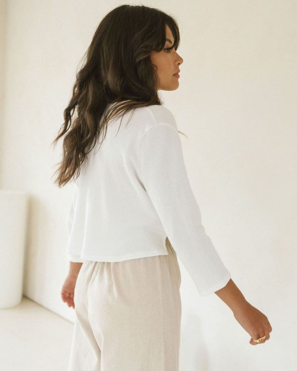 woman wearing the organic cotton waffle James Blouse in White paired with the Aura Pants by the brand Harly Jae