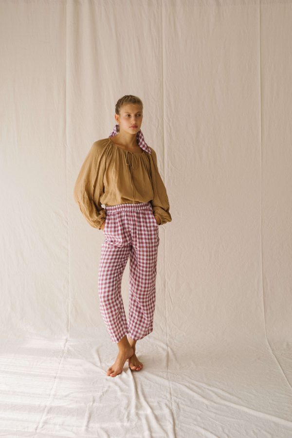 woman wearing the Mia Pants in Cherry Gingham by the brand The Bare Road