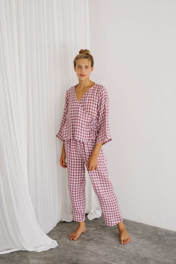 woman wearing the Mia Pants & Mia Wrap Top in Cherry Gingham by the brand The Bare Road