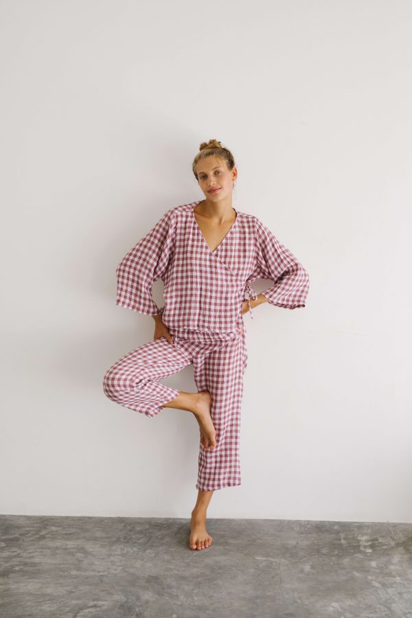 woman wearing the Mia Pants & Mia Wrap Top in Cherry Gingham by the brand The Bare Road
