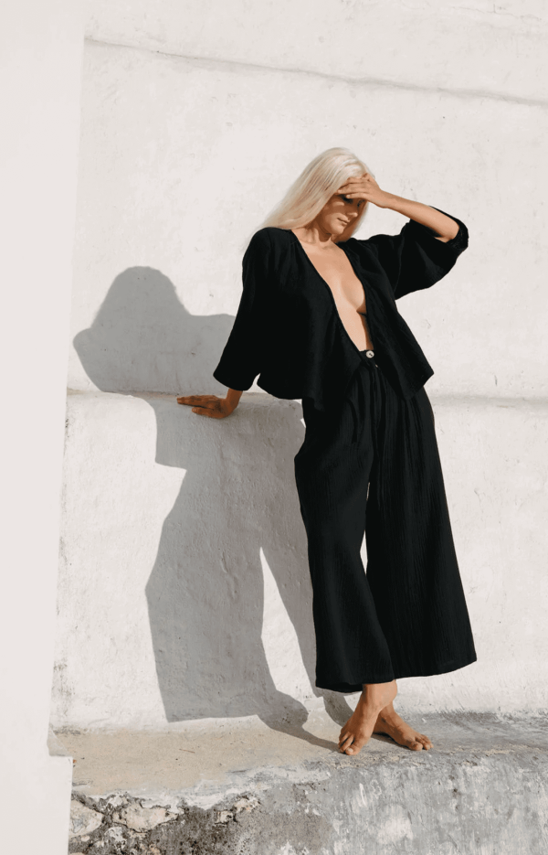 woman wearing the Mia Wrap Top in Black by the brand The Bare Road