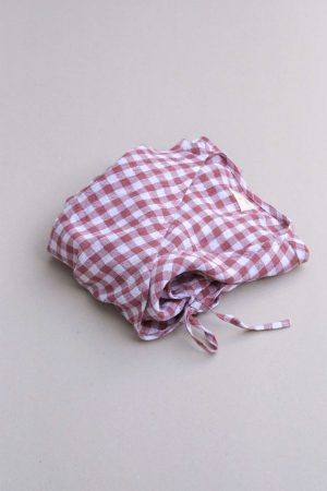 flatlay of the Mia Wrap Top in Cherry Gingham by the brand The Bare Road