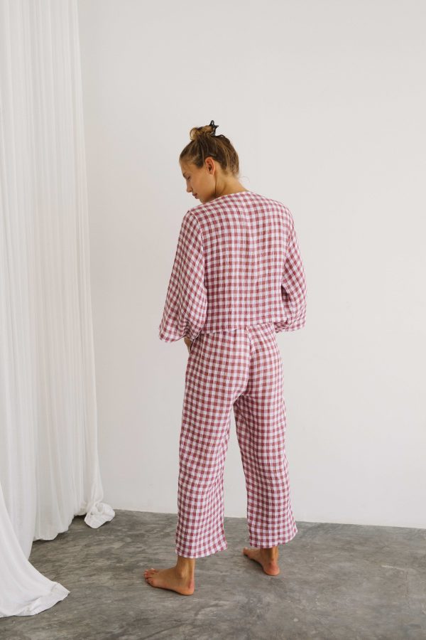 woman wearing the Mia Wrap Top & Mia Pants in Cherry Gingham by the brand The Bare Road