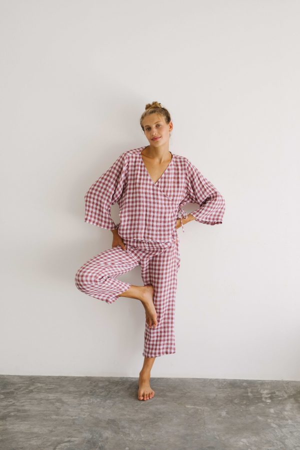 woman wearing the Mia Wrap Top & Mia Pants in Cherry Gingham by the brand The Bare Road