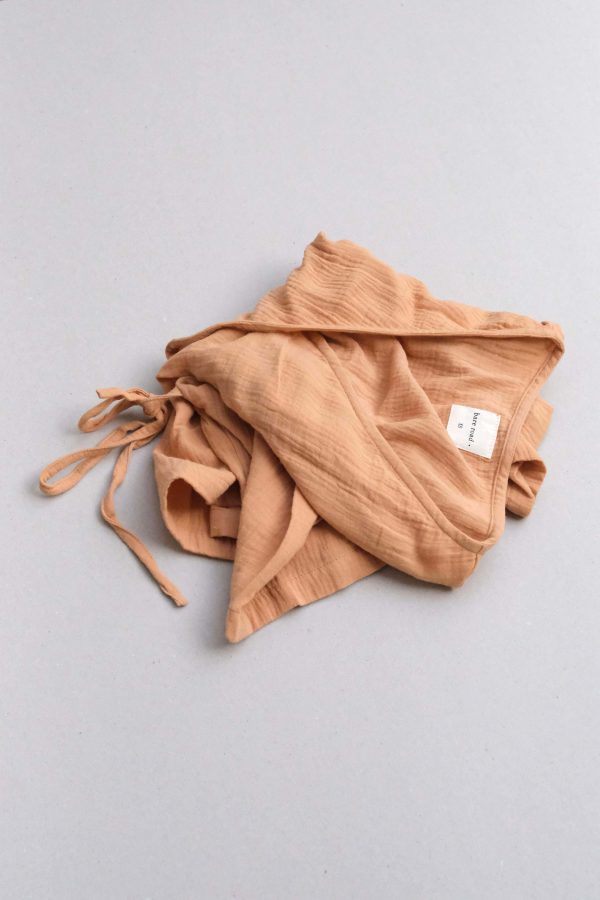 the Mia Wrap Top in Peach by the brand The Bare Road