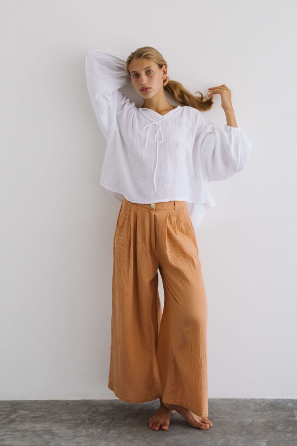 woman wearing the Poppy Pants in Peach by the brand The Bare Road