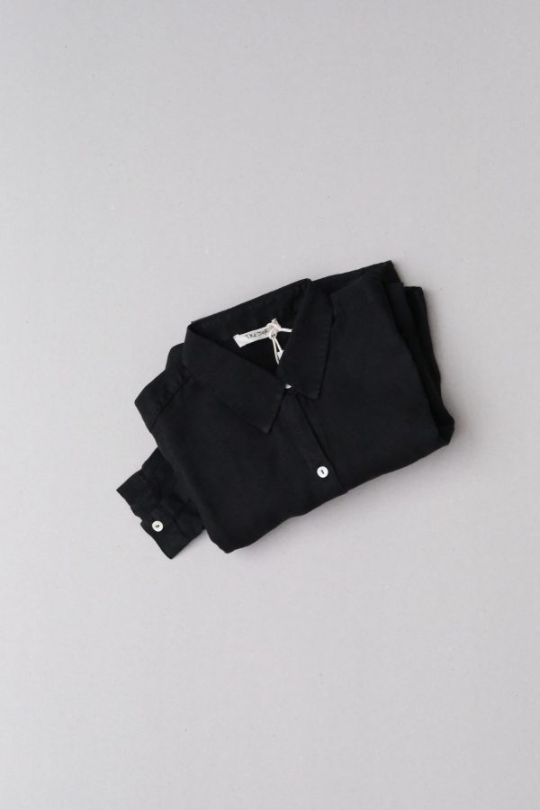 flatlay of the folded Allie Shirt in Black by the brand The Sept