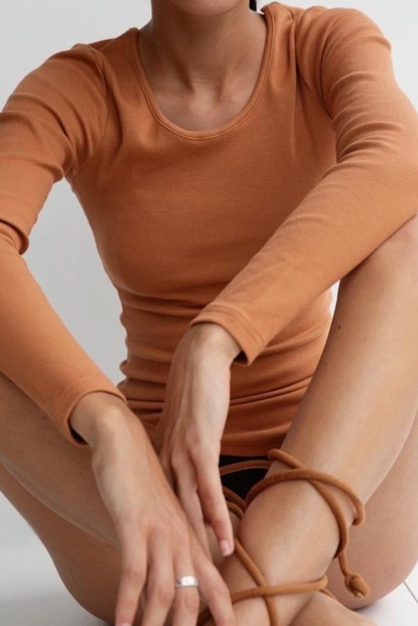 woman wearing the Mel Longsleeve in Caramel by the brand The Sept