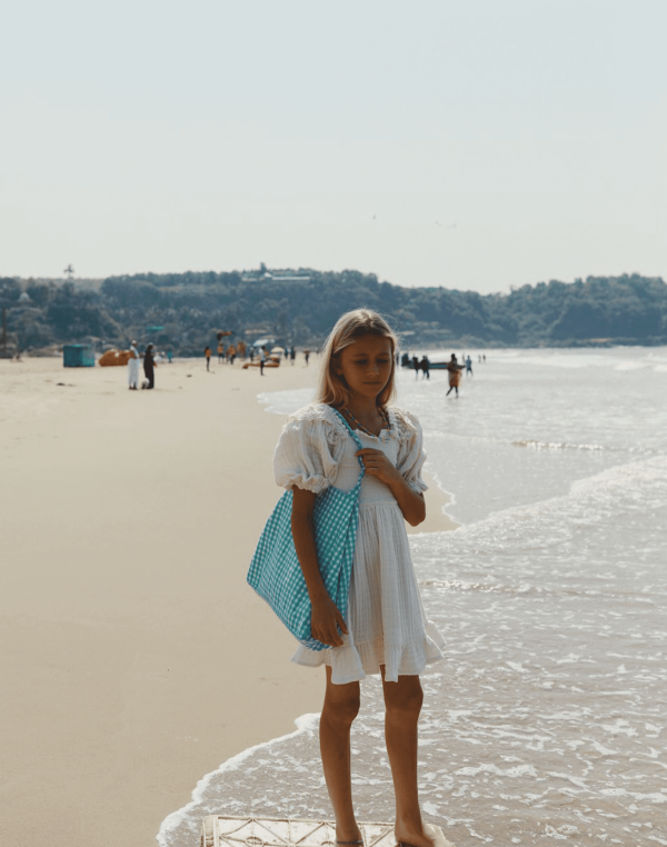 the Greta Dress in Undyed paired with the Daphne Tote by the brand Yoli & Otis