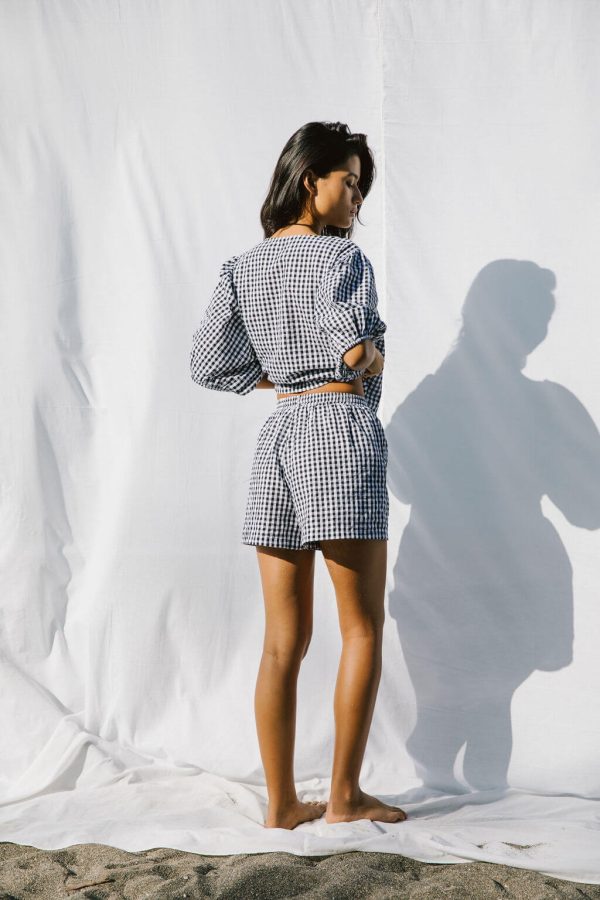 woman wearing the Ella Wrap Top & Maddie Shorts in Black Gingham by the brand The Bare Road