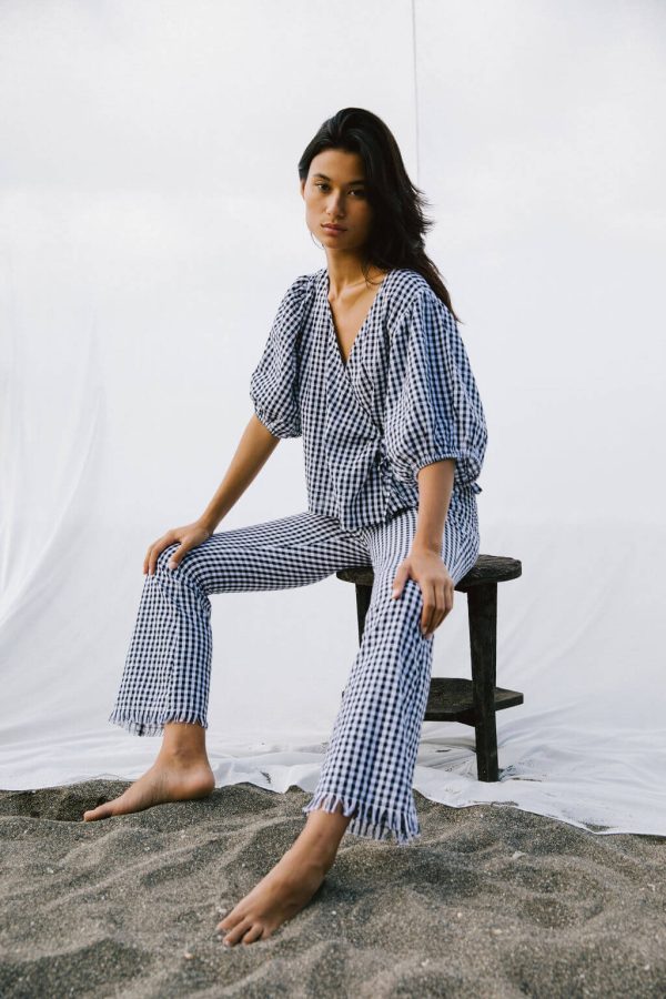 woman wearing the Ella Wrap Top in Black Gingham by the brand The Bare Road