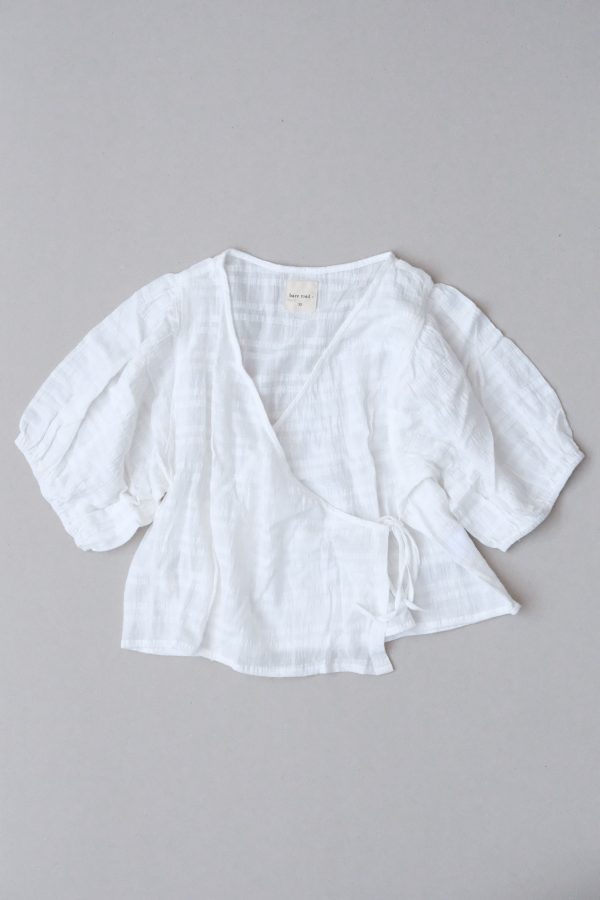 flatlay of the Ella Wrap Top in White Textured by the brand The Bare Road