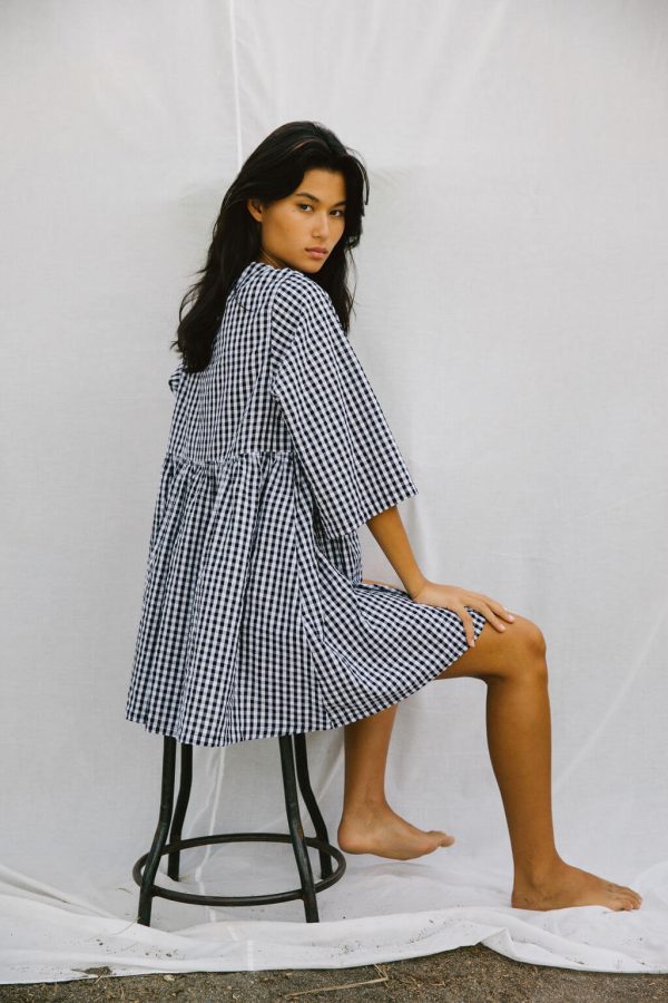 woman wearing the Holiday Wrap Dress in Black Gingham by the brand The Bare Road