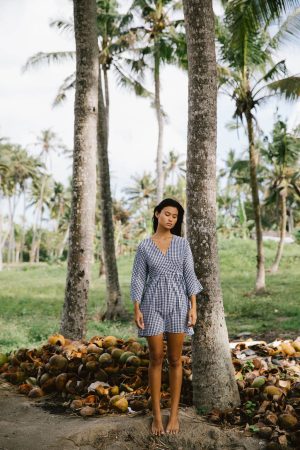 woman wearing the Holiday Wrap Dress in Black Gingham by the brand The Bare Road