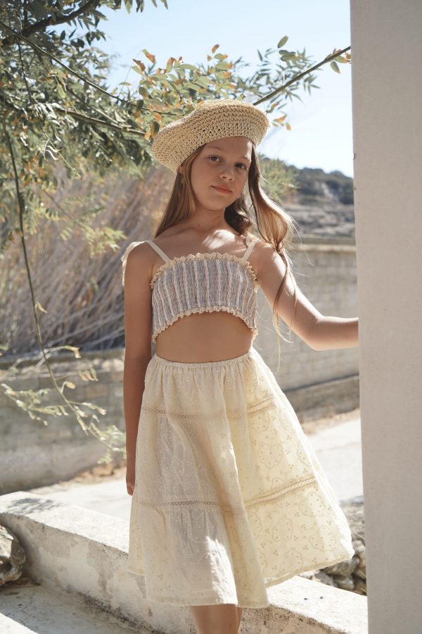 girl wearing the Baia Skirt in cotton Creme Broderie, paired with the Agnes Swim Set in Sicilian Stripe by the Australian brand House of Paloma, curated by Morsel Store