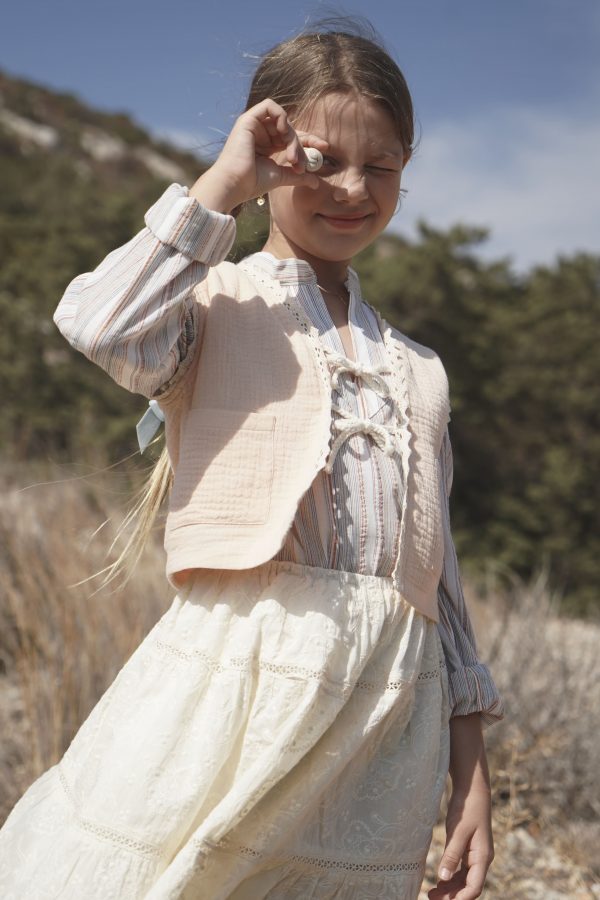 girl wearing the Baia Skirt in cotton Creme Broderie, paired with the Jule Tunic in Sicilian Stripe & Pasquelina Vest in Peach Sorbet by the Australian brand House of Paloma, curated by Morsel Store