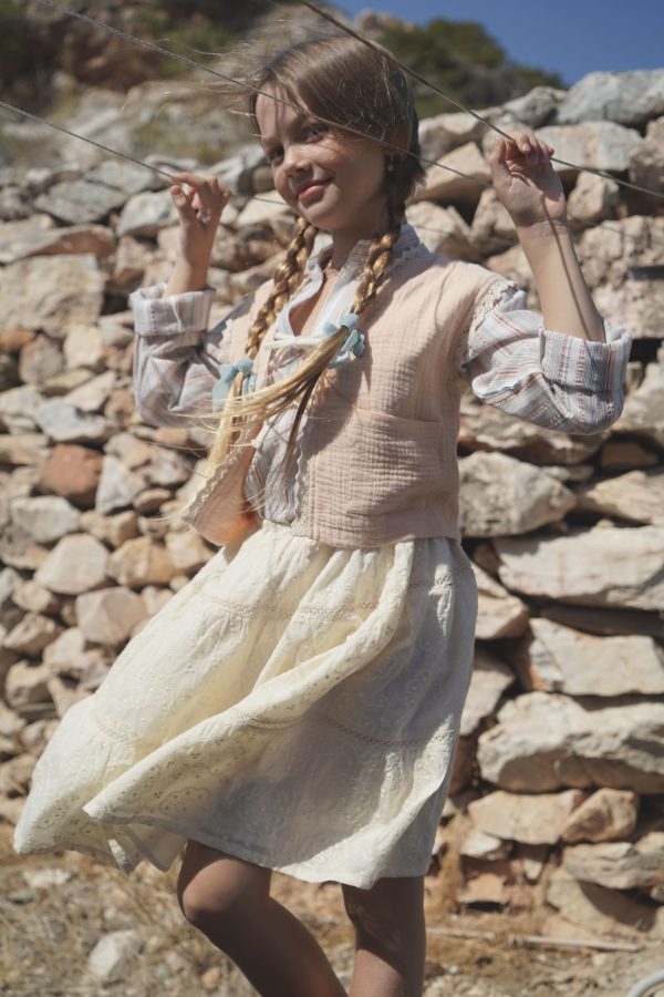 girl wearing the Baia Skirt in cotton Creme Broderie, paired with the Jule Tunic in Sicilian Stripe & Pasquelina Vest in Peach Sorbet by the Australian brand House of Paloma, curated by Morsel Store