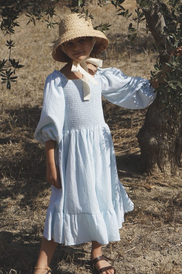 girl wearing the Hellenica Dress in cotton Pique Nique gingham fabric and the Jean Belle Raffia Hat by the sustainable brand House of Paloma, curated by Morsel Store