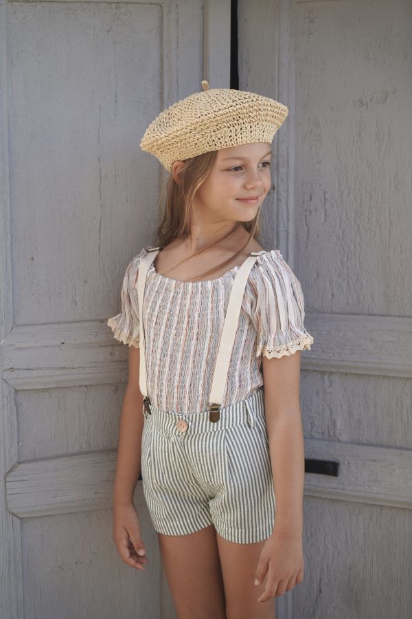 girl wearing the Sirene Blouse in Sicilian Stripe fabric, paired with the Jean Michel Short in Olive Parasol and a raffia hat, by the sustainable brand House of Paloma, curated by Morsel Store