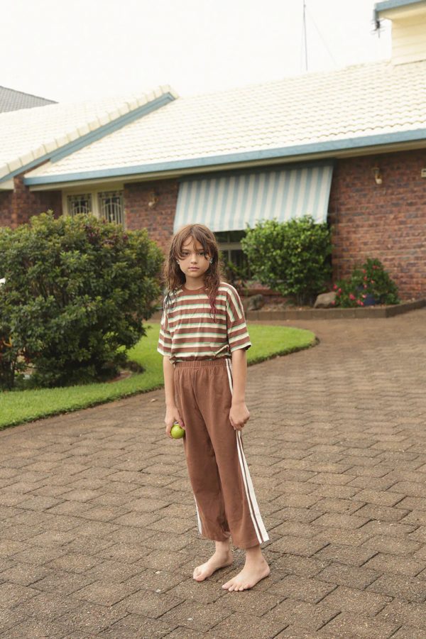 girl wearing the Oversized Tee in Brown Retro Stripe paired with the Racer Pants in Cocoa Brown by the brand Summer and Storm, curated by Morsel Store
