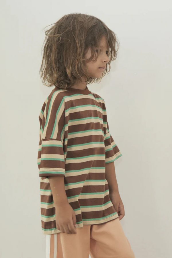 boy wearing the Oversized Tee in Brown Retro Stripe paired with the Racer Pants in Peach by the brand Summer and Storm, curated by Morsel Store