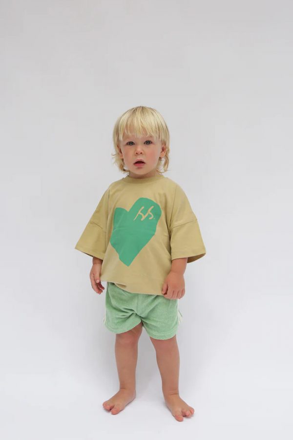 boy wearing the Oversized Tee in SS Green Heart paired with the Racer Shorts in Moss by the brand Summer and Storm, curated by Morsel Store