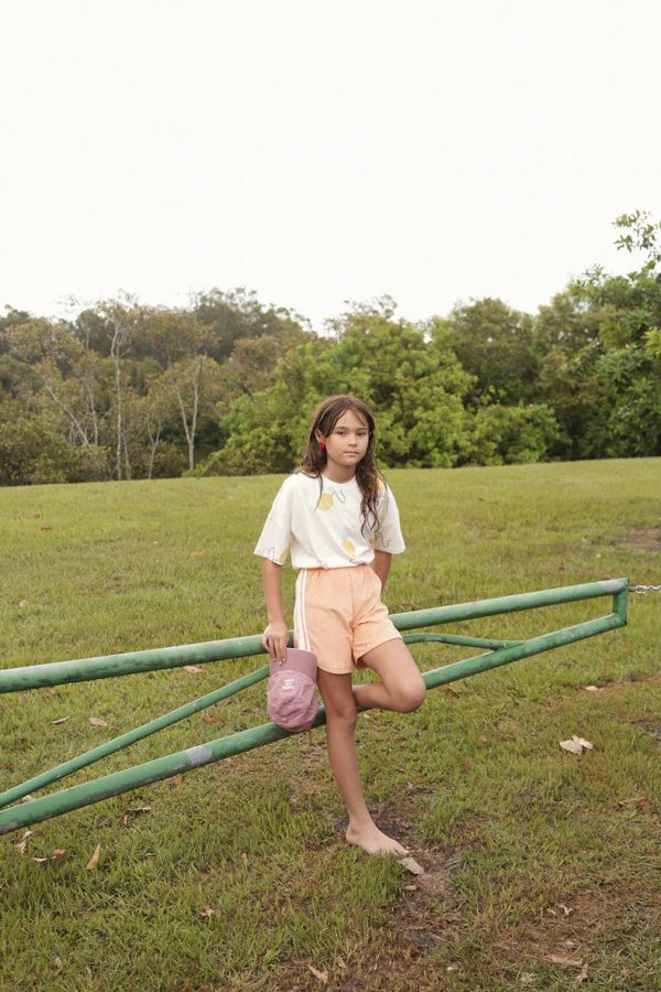 girl wearing the Racer Terry Shorts in Peach paired with the Oversized Tee in Balloon by the brand Summer and Storm, curated by Morsel Store