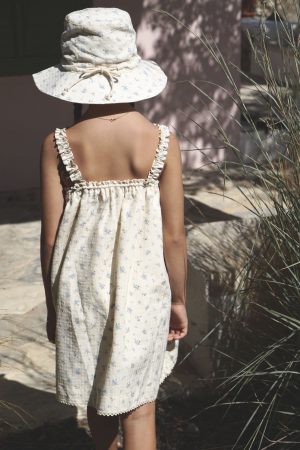 the cotton Daphne Dress in Fleur Bleue paired with the matching Hydra Hat by the brand House of Paloma, curated by Morsel Store