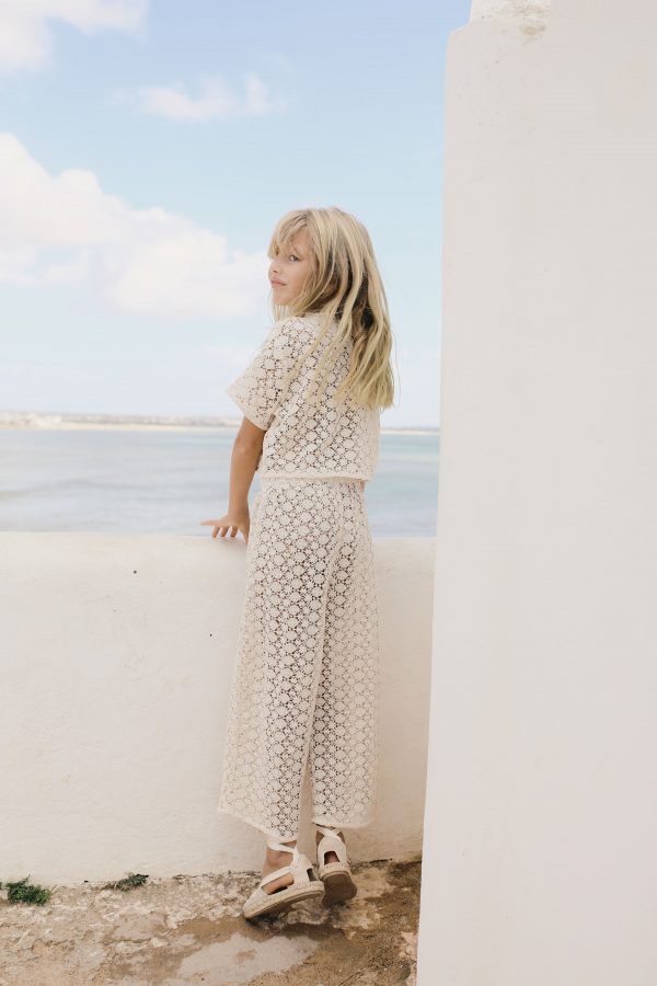 girl wearing the organic cotton Crochet Pants in Ecru paired with the matching Crochet Top by the sustainable brand Liilu, curated by Morsel Store, located on Mallorca