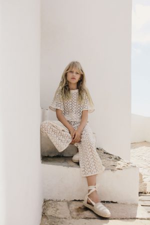 girl wearing the organic cotton Crochet Pants in Ecru paired with the matching Crochet Top by the sustainable brand Liilu, curated by Morsel Store, located on Mallorca