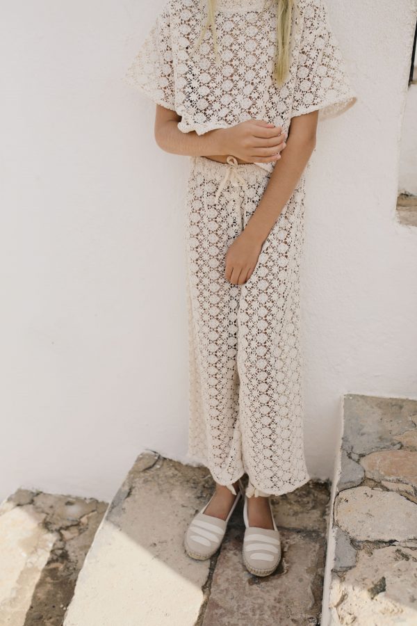 girl wearing the organic cotton Crochet Pants in Ecru paired with the matching Crochet Top by the sustainable brand Liilu, curated by Morsel Store, located on Mallorca