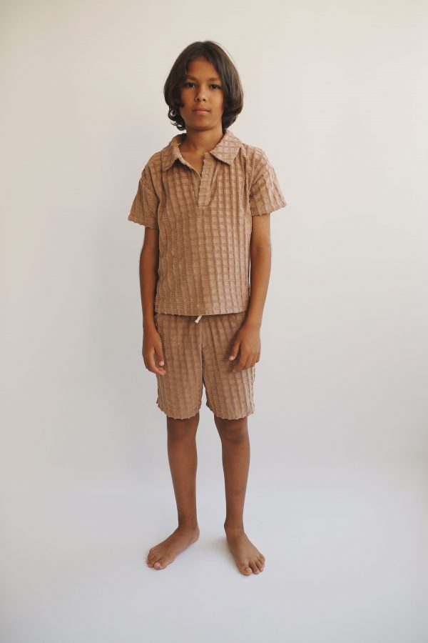boy wearing the Ben Bermuda in Chestnut organic waffle cotton, paired with the matching Lio Polo by the sustainable brand Liilu, curated by Morsel Store, located on Mallorca