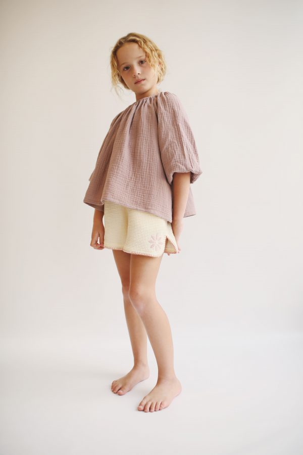 girl wearing the Liilu Blouse in Pale Mauve organic muslin cotton by the sustainable brand LiiLU, curated by Morsel Store located on Mallorca