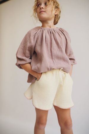 girl wearing the Liilu Blouse in Pale Mauve organic muslin cotton by the sustainable brand LiiLU, curated by Morsel Store located on Mallorca