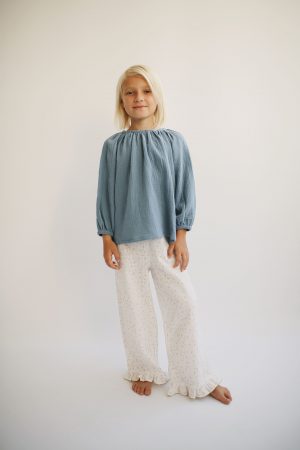 girl wearing the Liilu Blouse in Storm Blue organic muslin cotton by the sustainable brand LiiLU, curated by Morsel Store located on Mallorca