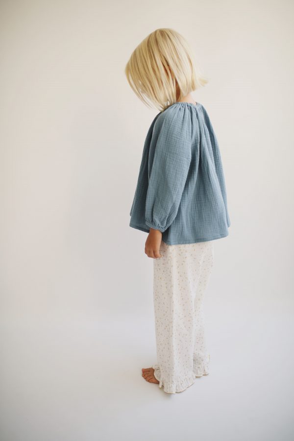 girl wearing the Liilu Blouse in Storm Blue organic muslin cotton by the sustainable brand LiiLU, curated by Morsel Store located on Mallorca