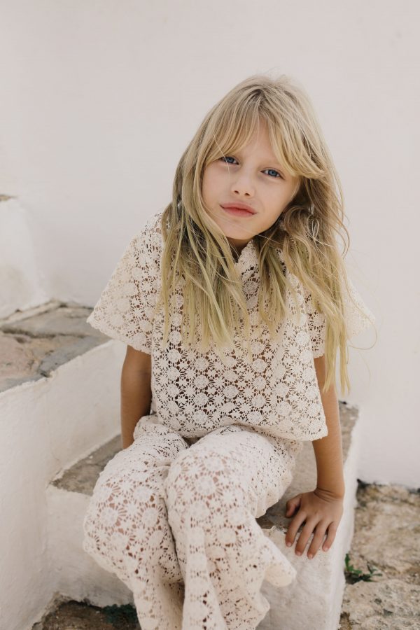 girl wearing the Crochet T-shirt in Ecru organic cotton paired with the matching Crochet Pant by the sustainable brand Liilu, curated by Morsel Store, located on Mallorca
