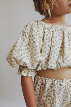 girl wearing the Leandra Blouse in Ecru Floral organic cotton paired with the matching Bella Shorts by the sustainable brand LiiLU, curated by Morsel Store, located on Mallorca