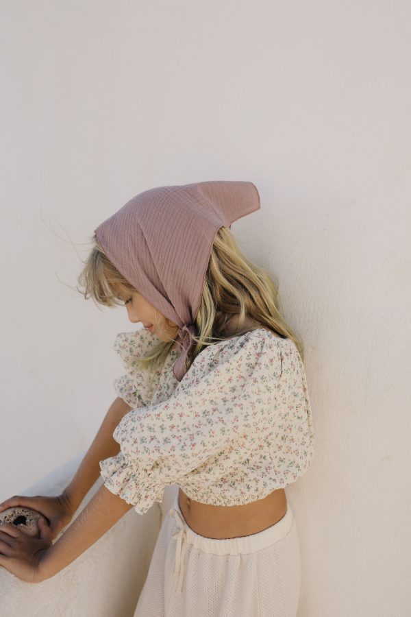 girl wearing the Leandra Blouse in Ecru Floral organic cotton paired with a bandana and Sweta Pants by the sustainable brand LiiLU, curated by Morsel Store, located on Mallorca