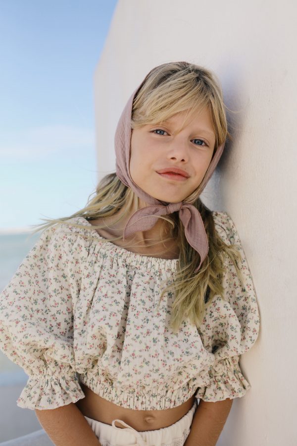 girl wearing the Leandra Blouse in Ecru Floral organic cotton paired with a bandana and Sweta Pants by the sustainable brand LiiLU, curated by Morsel Store, located on Mallorca