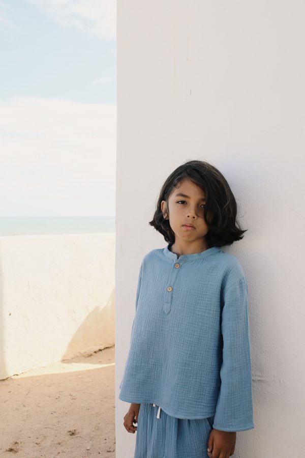 boy wearing the Leonard Shirt in Storm blue organic muslin cotton paired with the matching Levi Pant by the sustainable brand LiiLU, curated by Morsel Store located on Mallorca