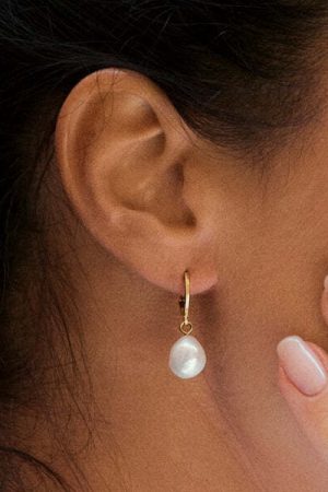 woman wearing the Estee Earrings in white nacre pearl by the sustainable brand Agapé Studio, curated by Morsel Store