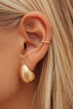 woman wearing the Mirada Earcuff and Figuera Earrings in gold by the sustainable jewelry brand Agapé Studio, curated by Morsel Store