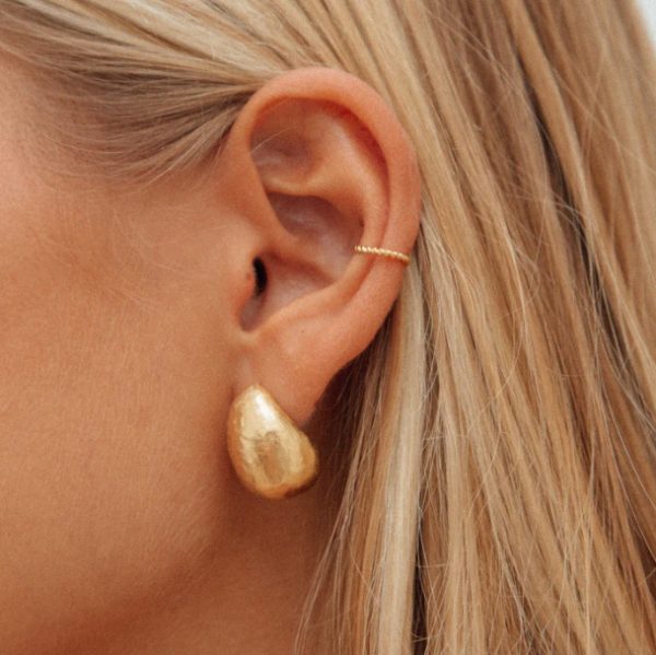 woman wearing the Mirada Earcuff and Figuera Earrings in gold by the sustainable jewelry brand Agapé Studio, curated by Morsel Store