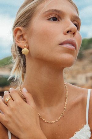 woman wearing the Pao Earrings in gold by the sustainable jewelry brand Agapé Studio, curated by Morsel Store