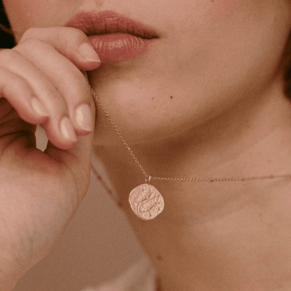 woman wearing the gold plated zodiac necklace - Pisces - by the sustainable jewellery brand Agapé Studio, curated by Morsel Store