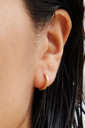 woman wearing the Gina Earrings in gold by the sustainable jewelry brand Agapé Studio (now Agapée), curated by Morsel Store